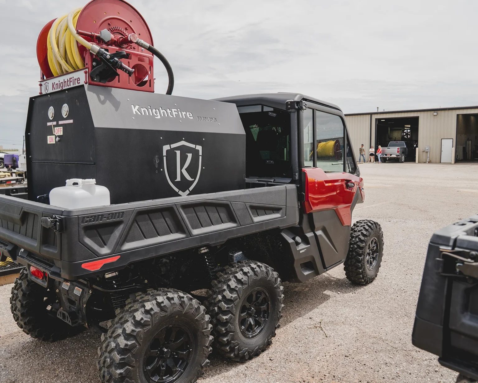 Knight Fire Armor unit with a red hose reel mounted on the bed of a Can-Am utility vehicle