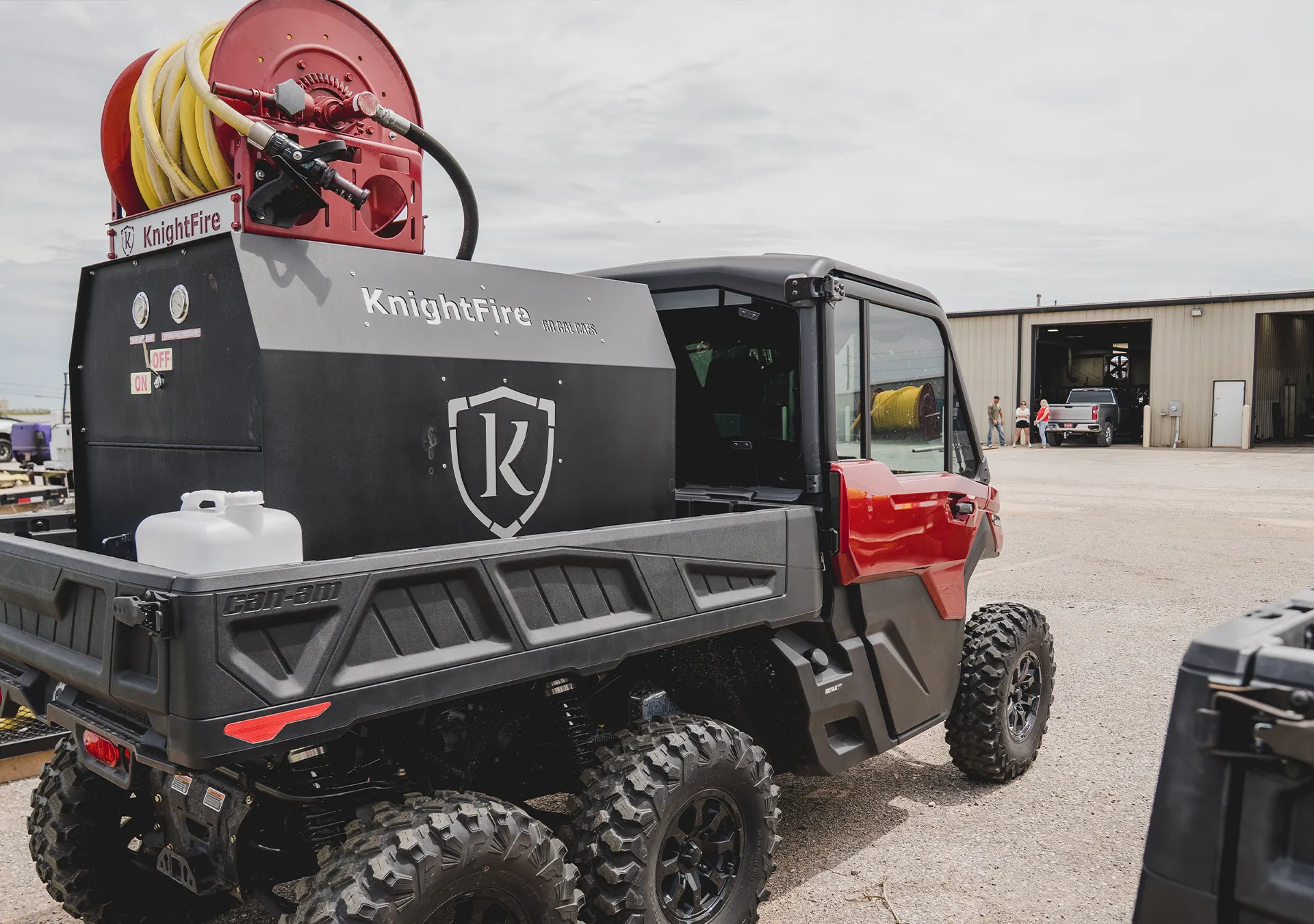 KnightFire fire suppression system mounted on the bed of a Can-Am utility vehicle, featuring a red hose reel, foam tank, and control gauges for rapid deployment.
